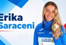 Erika Saraceni holding a gold medal in Italian athletics uniform