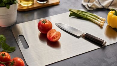 Titanium cutting board on a kitchen counter with vegetables and a chef knife